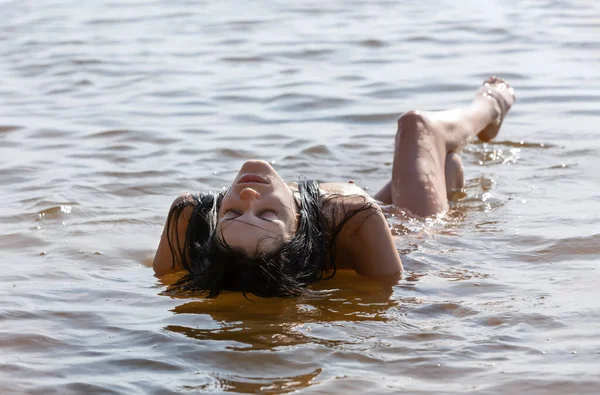 Doğanın tadını çıkaran güzel bir kız. Sahilde poz veren genç bir kız. Denizde çıplak bir kadın