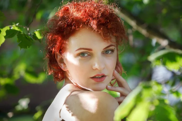 Güneş Işınlarıyla Aydınlatılmış Ağaçların Arasında Genç Kızıl Saçlı Bir Kadının — Stok fotoğraf