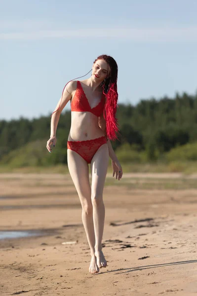 야외에서 자연을 즐기는 아름다운 수영복을 여자가 모래를 바다를 갑니다 — 스톡 사진