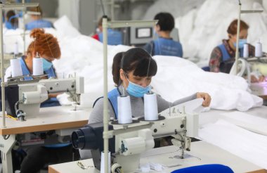 CHERNIGIV, UKRAINE - 06 Ekim 2020: Chernigiv, Ukrayna 'da TK-Style dikiş fabrikasında covid-19 pandemisi sırasında sağlıkçılar ve doktorlar için koruyucu elbiseler dikmek