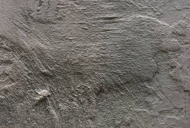 Kalıplı gri bir duvarın yakın çekimi, pürüzlü, düzensiz yüzeyler, karmaşık desenler ve ince renk değişimleri sergiliyor..