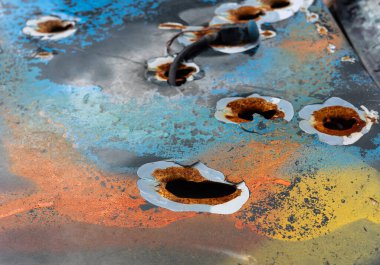 Ukrayna 'daki savaşın eserleri. Hasarlı bir araca yakın çekim. Silah sesi ile işaretlenmiş. Savaş ve şiddet izleri taşıyor..