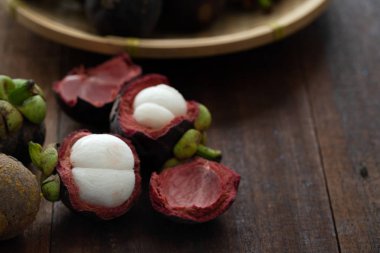 Ahşap arka plan üzerinde taze Mangosteen tropikal meyve yığını