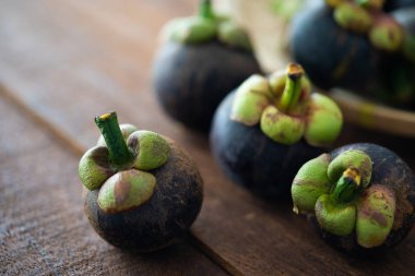 Ahşap arka plan üzerinde taze Mangosteen tropikal meyve yığını