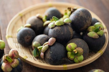 Ahşap arka plan üzerinde taze Mangosteen tropikal meyve yığını