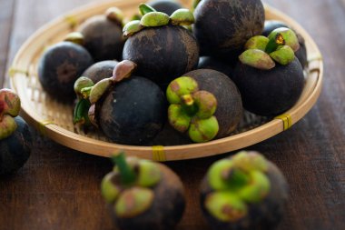 Ahşap arka plan üzerinde taze Mangosteen tropikal meyve yığını