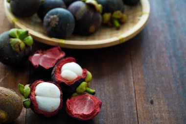 Ahşap arka plan üzerinde taze Mangosteen tropikal meyve yığını