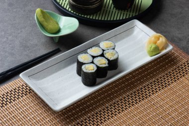 Geleneksel Japon Tamago Maki beyaz tabakta yumurta.