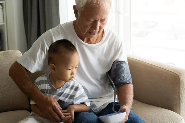 Azjatycka Dziadkowie Wnuk Monitorowania Ciśnienia Krwi — Zdjęcie stockowe