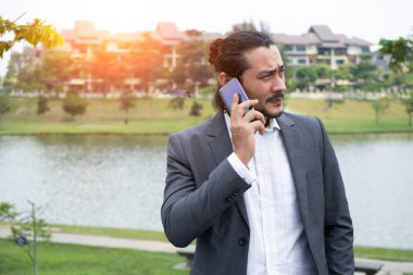 çekici karışık Orta Doğu görünümlü iş adamı ile bir telefon