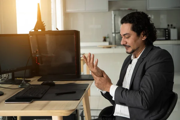 Handsome arab man suffering from wrist pain in office, closeu