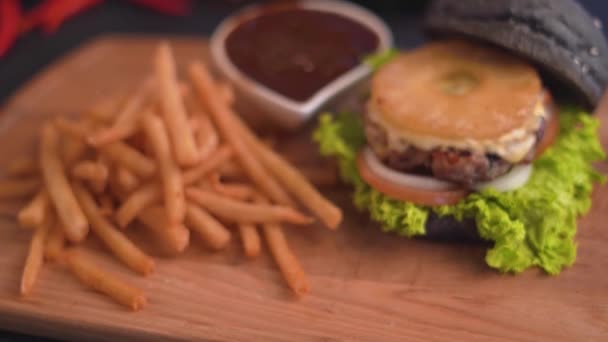 木製のまな板にフライド ポテトとイベリコ豚バーガーのクローズ アップ映像 — ストック動画