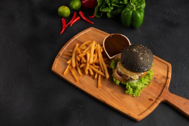 Ahşap kesme tahtası üzerinde Iberico domuz burger patates kızartması ile yüksek açılı görünüş