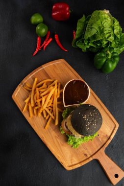 Iberico domuz burger patates kızartması ve sos üstten görünüm siyah yüzeyi