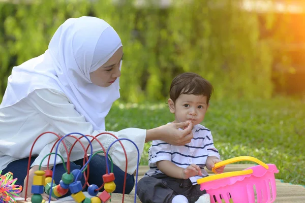 アジアのイスラム教徒の母と屋外に一緒に勉強している子 — ストック写真
