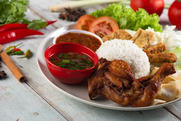 在白色木桌上的美味印尼传统米饭与鸡的特写镜头 — 图库照片