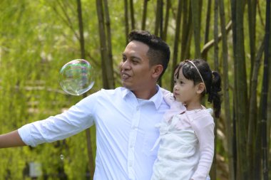 mutlu Asya baba ve kız parkta birlikte vakit