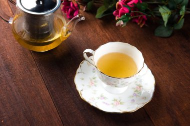 yakın çekim shot cam Çaydanlık ve ahşap masa pembe çiçekli çay