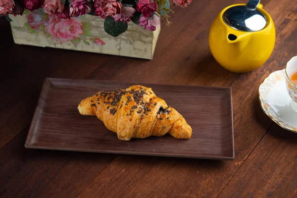 close-up shot of black sesame croissant with teapot