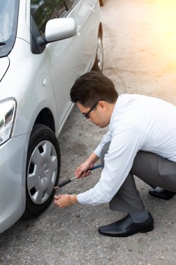 Asya adam onun araba lastik hava pompalama