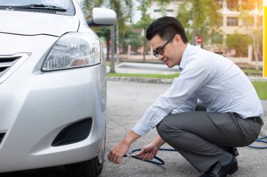 Asya adam onun araba lastik hava pompalama