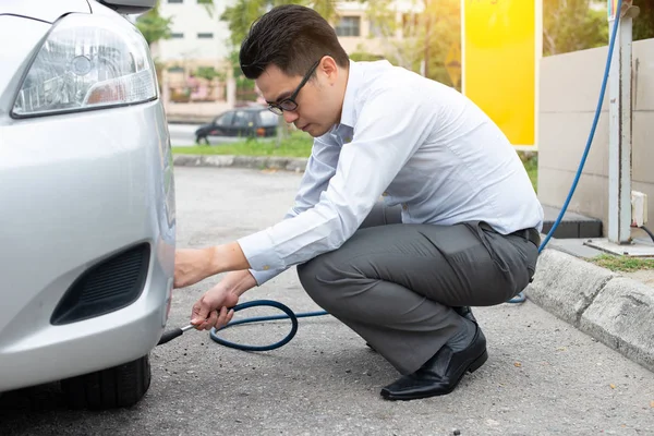 Asiat Pumpt Luft Seinen Autoreifen — Stockfoto