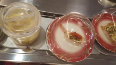 restoranda konveyör üzerinde çeşitli suşi yakın çekim görüntüleri