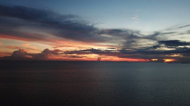 Okyanus üzerinde gün batımının havadan görünümü. Gökten, buluttan ve sudan başka bir şey yok.