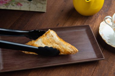 ahşap arka planda cımbız ile puf patry yakın çekim