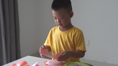 evde kağıt ev yapma sevimli asyalı çocuk