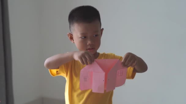 Bedårande Asiatisk Pojke Gör Papper Hus Hemma — Stockvideo