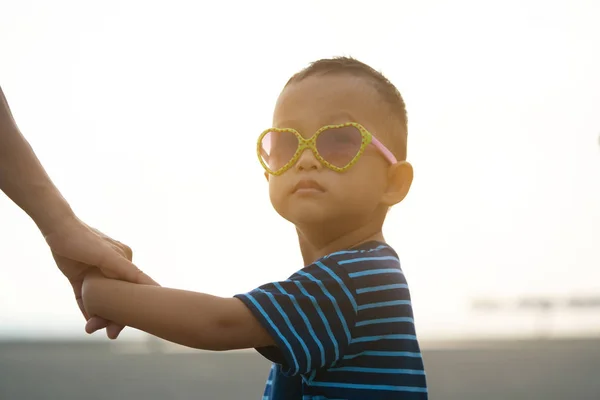 日没時にビーチを歩くアジアの少年 — ストック写真