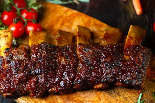 BBQ beef ribs steak served with hot chili pepper and fresh tomatoes top down view