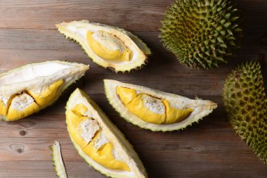 Durian yırtık ve taze, ahşap masa üzerinde sarı renk ile durian kabuğu