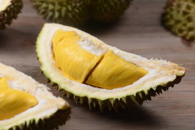 Durian yırtık ve taze, ahşap masa üzerinde sarı renk ile durian kabuğu