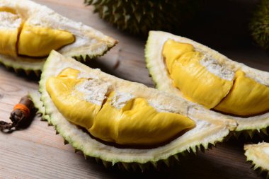 Durian yırtık ve taze, ahşap masa üzerinde sarı renk ile durian kabuğu