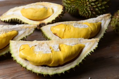 Durian yırtık ve taze, ahşap masa üzerinde sarı renk ile durian kabuğu