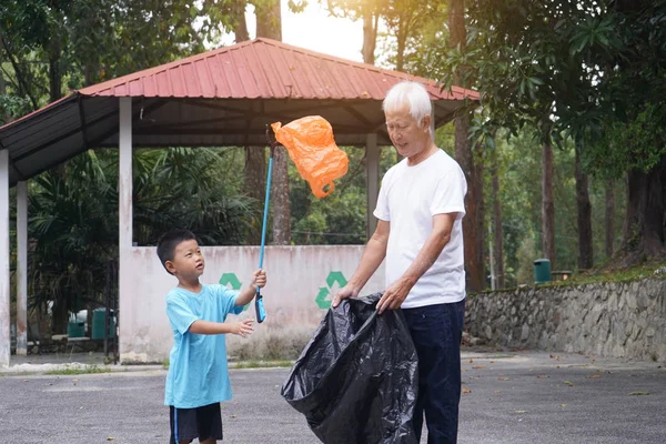 祖父と孫が路上でゴミを拾い — ストック写真