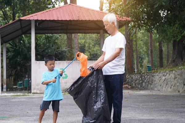 祖父と孫が路上でゴミを拾い — ストック写真