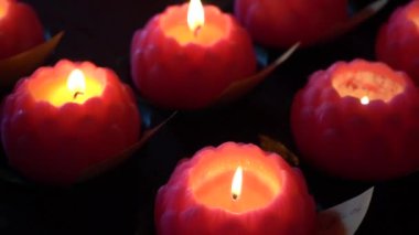 Akşam kırmızı mumların yandığı yakın çekim görüntüler.