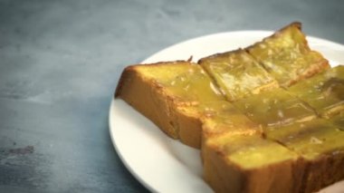 Tereyağlı ve yoğunlaştırılmış sütle ekmekli tostun yakın çekim görüntüleri.