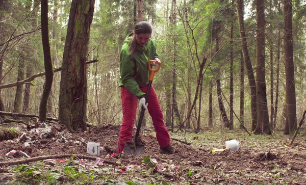 Kadın ekolojist ormandaki bir toprak yarık kazma