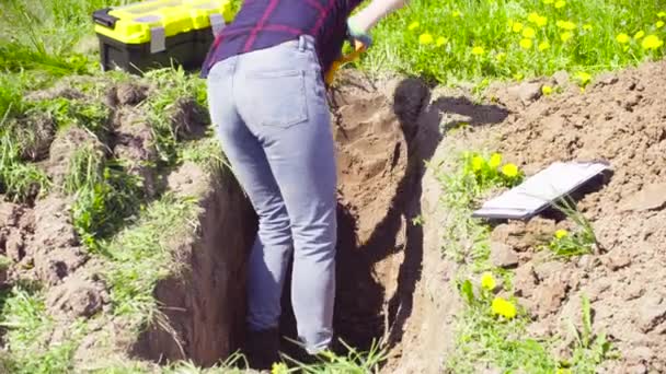 Γυναίκα οικολόγος στο Λιβάδι σκάψιμο μια σχισμή εδάφους — Αρχείο Βίντεο