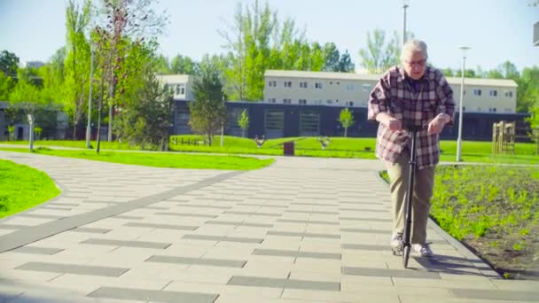 La anciana aprendiendo a montar un scooter — Vídeos de Stock