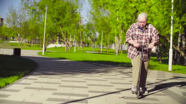 La anciana aprendiendo a montar un scooter — Vídeo de stock