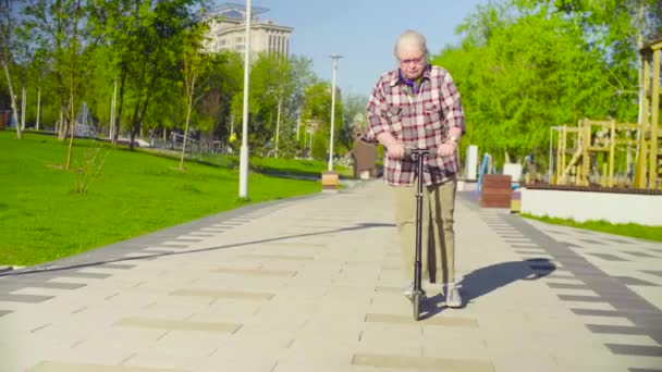 A velha aprendendo a andar de scooter — Vídeo de Stock