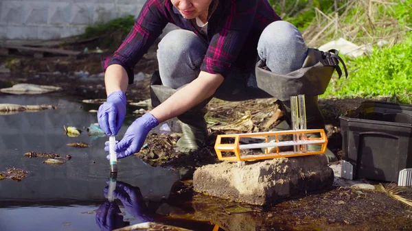 Mãos de ecologista recolhendo amostras da água . — Fotografia de Stock
