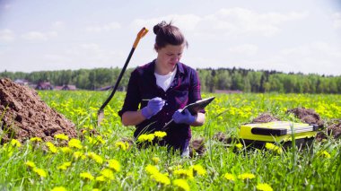 Scientist ecologist on a meadow marking something clipart