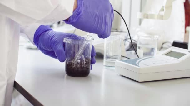 Hands of a scientist measuring pH of the sample — Stock Video