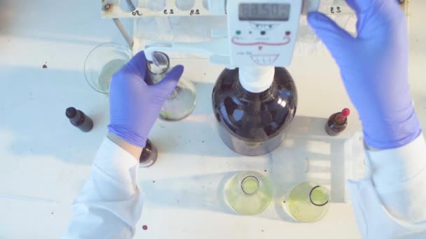 Hands of a scientist titrating solution — Stock Video